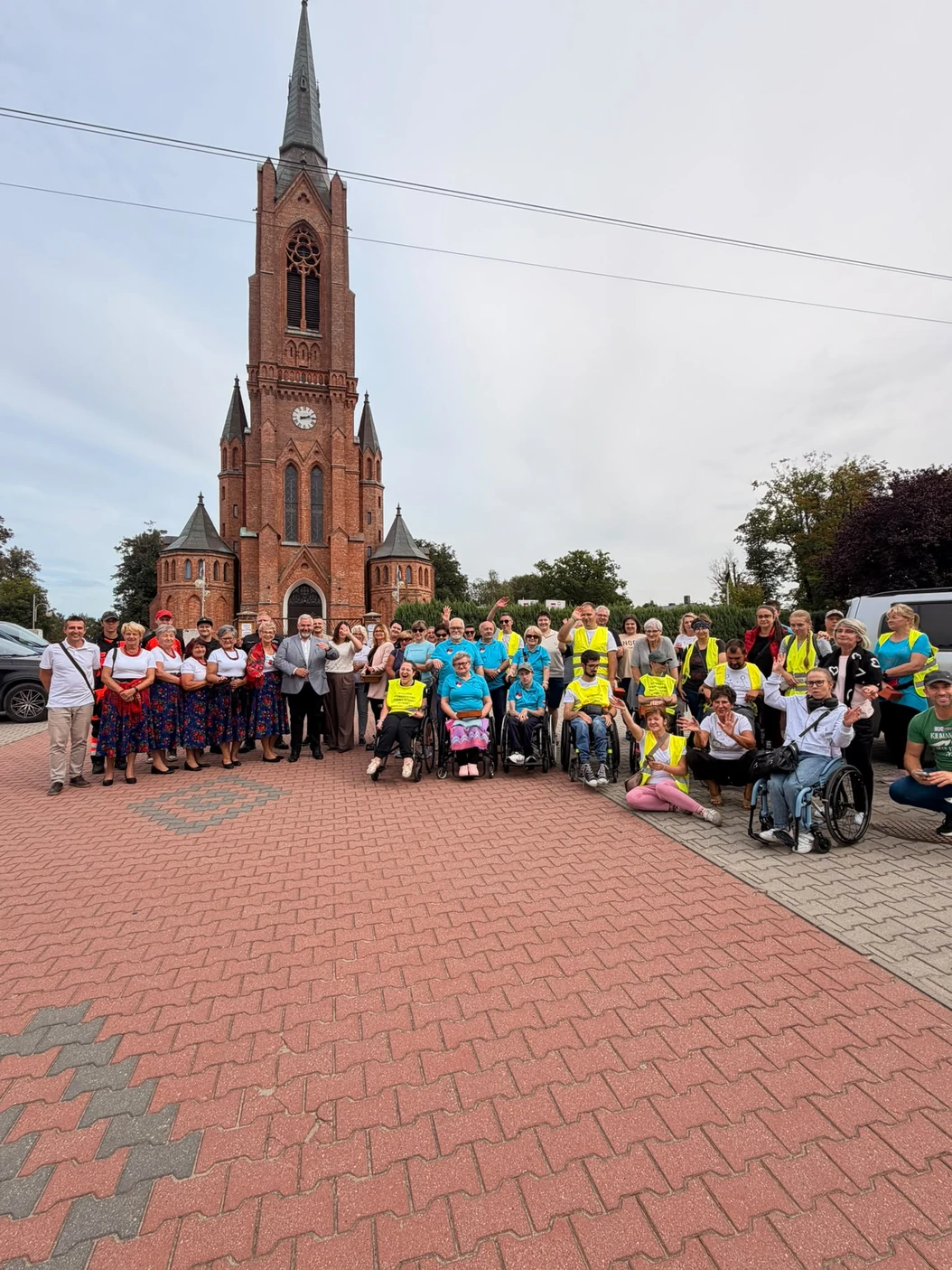 Wspólne zdjęcie uczestników, opiekunów i mieszkańców przed kościołem na trasie sztafety.